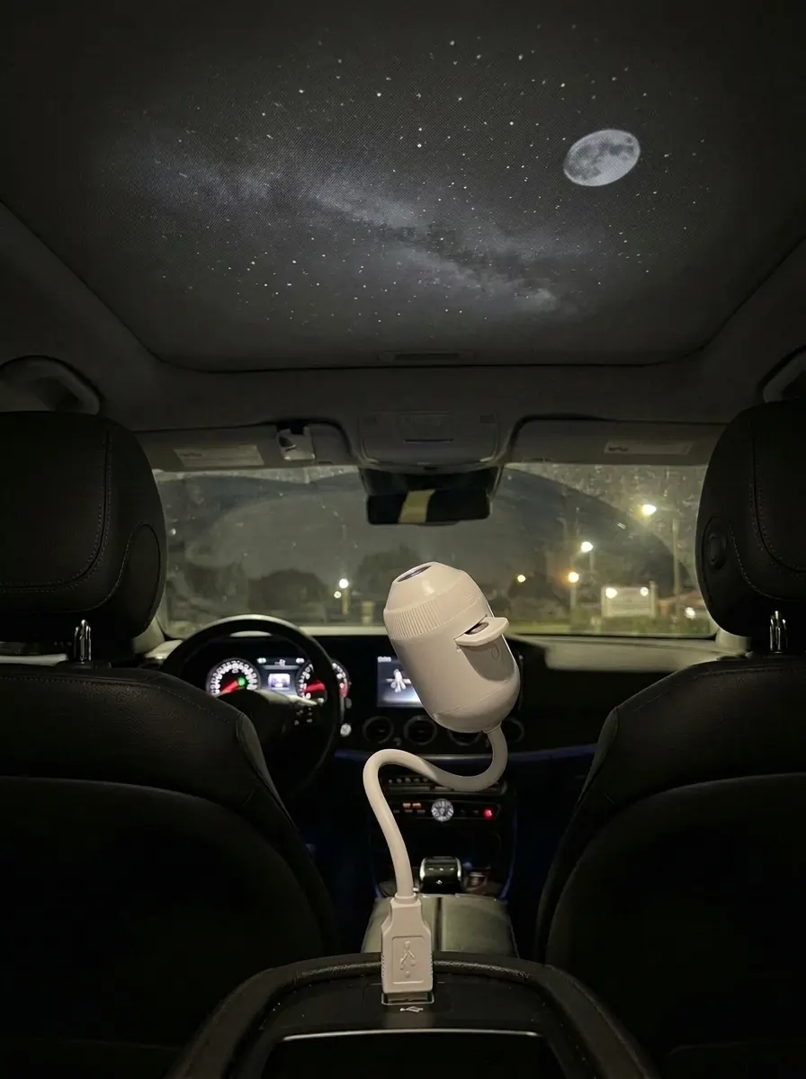 Render of a parked car at night with SkyPlug in the centre console projecting stars and a moon onto the roof lining.